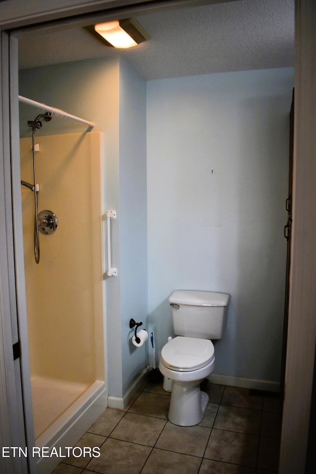 33 Wood Ln, Sparta, TN 38583 - full bath with a shower stall, toilet, tile patterned floors, baseboards, and a textured ceiling