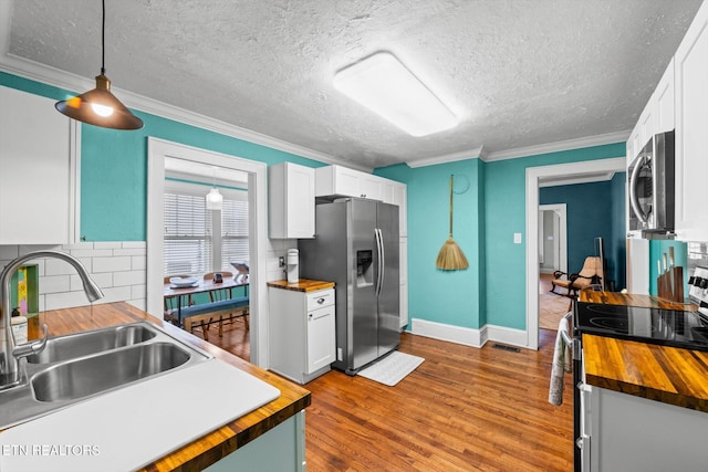 1735 NE Albert Ave, Knoxville, TN 37917 - kitchen with wood counters, stainless steel appliances, a sink, decorative backsplash, and crown molding