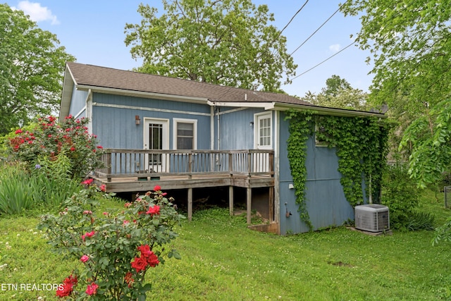 back of house with central AC unit, a wooden deck, and a lawn