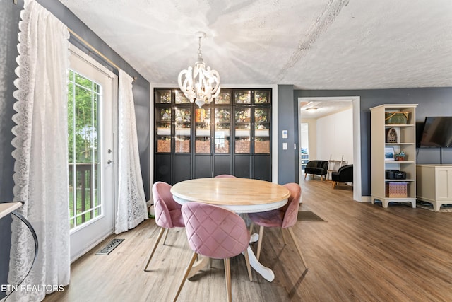 dining room featuring a chandelier, wood finished floors, and baseboards