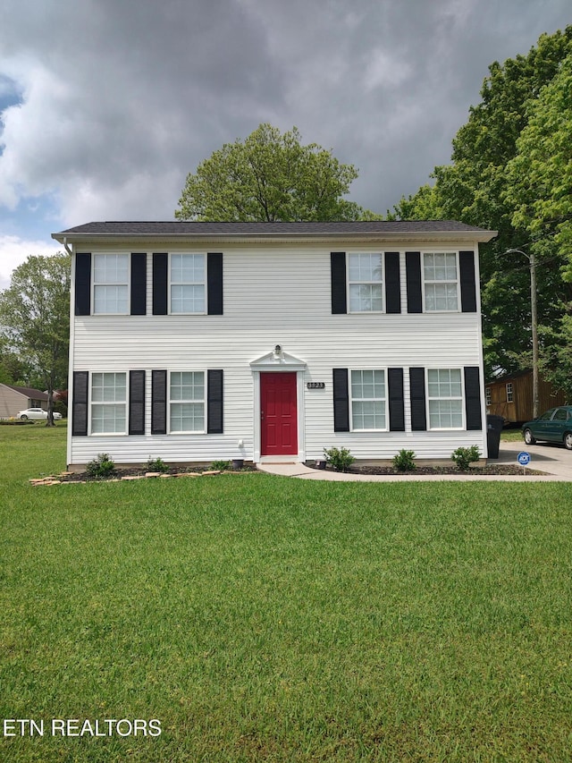 colonial house featuring a front lawn