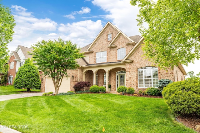 12618 Hunters Creek Ln, Knoxville, TN 37922 - traditional home with brick siding, concrete driveway, a front lawn, and a garage