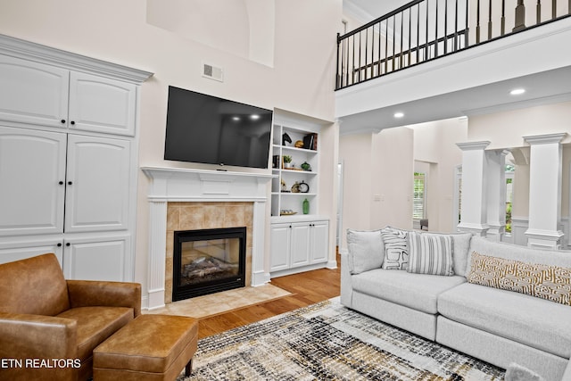 12618 Hunters Creek Ln, Knoxville, TN 37922 - living area featuring a fireplace, decorative columns, light wood-style flooring, and a high ceiling