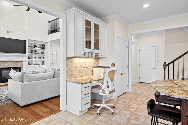 12618 Hunters Creek Ln, Knoxville, TN 37922 - home office featuring crown molding, a glass covered fireplace, light tile patterned flooring, recessed lighting, and built in study area