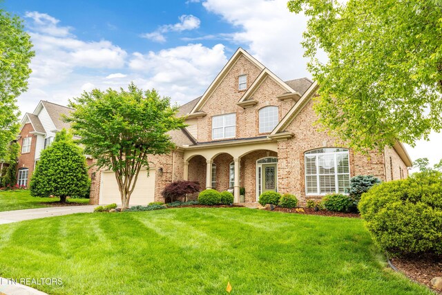 12618 Hunters Creek Ln, Knoxville, TN 37922 - traditional home with brick siding, concrete driveway, a front lawn, and a garage