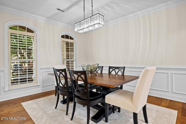 12618 Hunters Creek Ln, Knoxville, TN 37922 - dining area with a chandelier, ornamental molding, wood finished floors, a decorative wall, and wainscoting