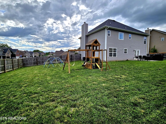 back of property with a playground, a chimney, and a patio area