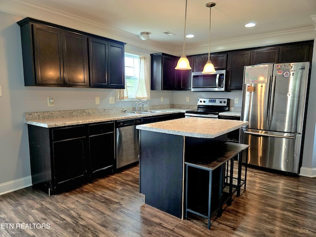 kitchen featuring stainless steel appliances, a sink, crown molding, dark wood-type flooring, and baseboards