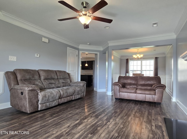 living area with a chandelier, dark wood-type flooring, ornamental molding, a ceiling fan, and wainscoting