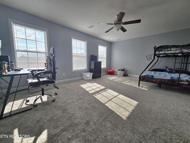 carpeted home office featuring baseboards and a ceiling fan