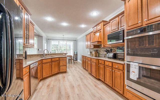 515 Oak Landing Ln Unit 4, Knoxville, TN 37934 - kitchen featuring appliances with stainless steel finishes, a sink, crown molding, light wood finished floors, and a peninsula