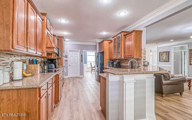 515 Oak Landing Ln Unit 4, Knoxville, TN 37934 - kitchen with a peninsula, freestanding refrigerator, glass insert cabinets, brown cabinets, and light wood finished floors