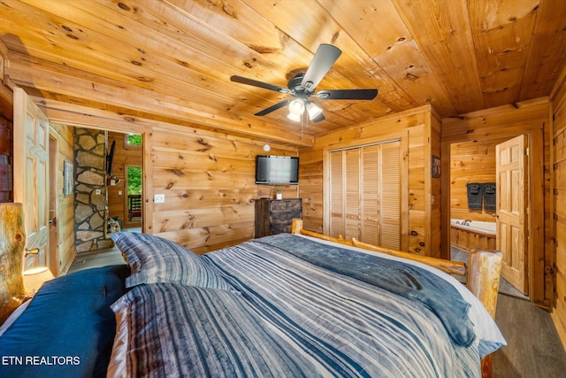 bedroom featuring wood ceiling, wooden walls, wood finished floors, a ceiling fan, and a closet