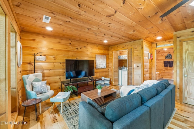 living room featuring wooden ceiling, light wood-style flooring, wood walls, recessed lighting, and separate washer and dryer
