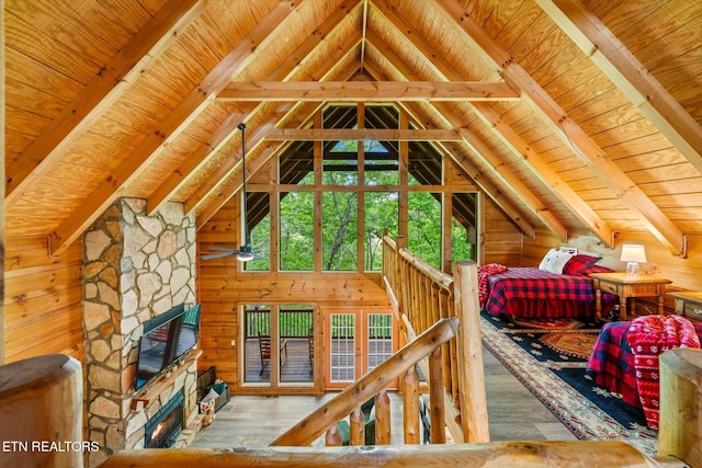 bedroom with wooden ceiling, wood finished floors, a fireplace, wood walls, and access to exterior
