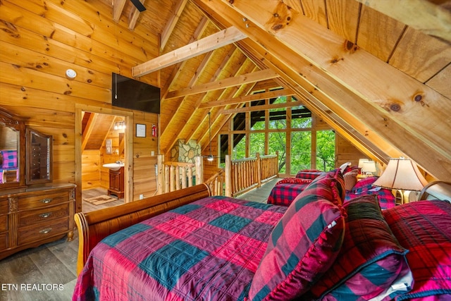 bedroom with wood walls, wood finished floors, wood ceiling, and ensuite bath