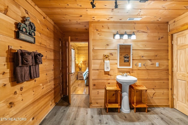 bathroom featuring wooden ceiling, wooden walls, and wood finished floors