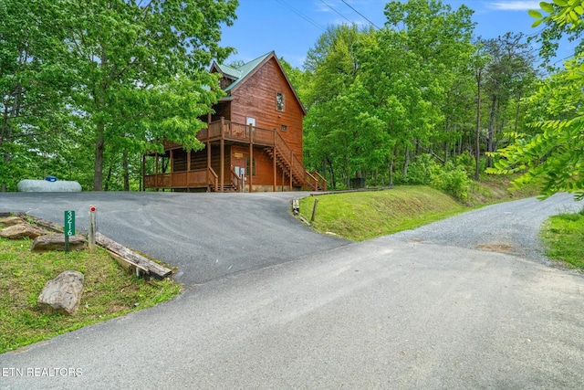 view of asphalt driveway featuring stairway