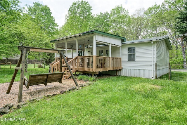back of house with a wooden deck, french doors, and metal roof