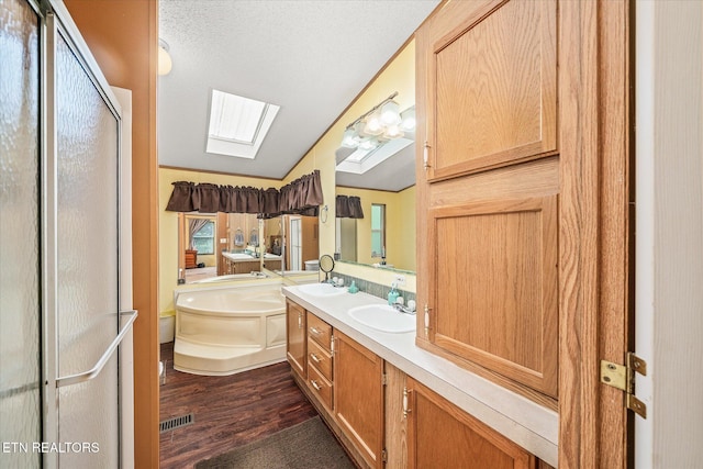 bathroom with a skylight, lofted ceiling, a shower stall, wood finished floors, and a bath