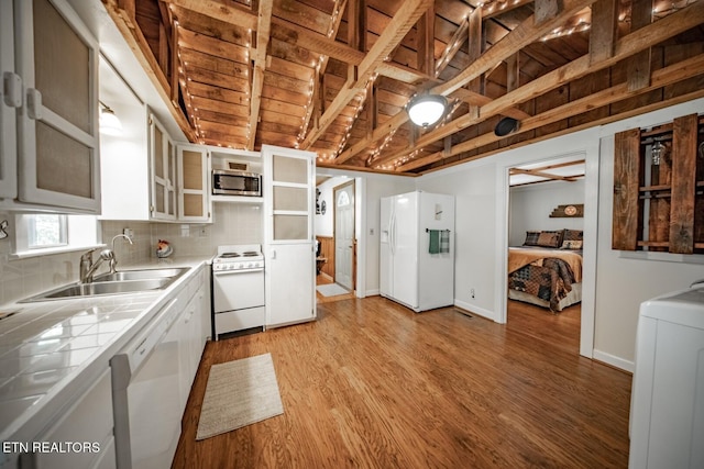 kitchen featuring white appliances, tile counters, a sink, wood ceiling, and light wood-style floors