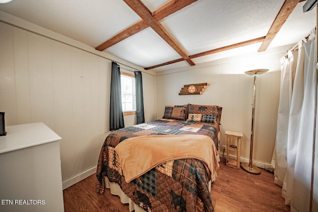 bedroom with wood finished floors, beam ceiling, coffered ceiling, and baseboards
