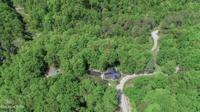 aerial view of property and surrounding area featuring a heavily wooded area