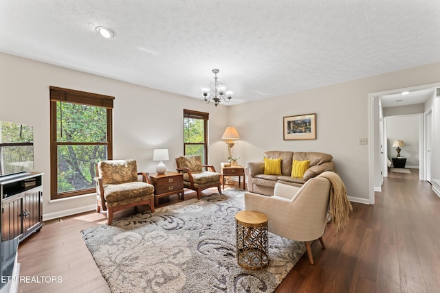 9945 Tierra Verde Dr, Knoxville, TN 37922 - living room featuring a chandelier, dark wood-type flooring, baseboards, and a textured ceiling
