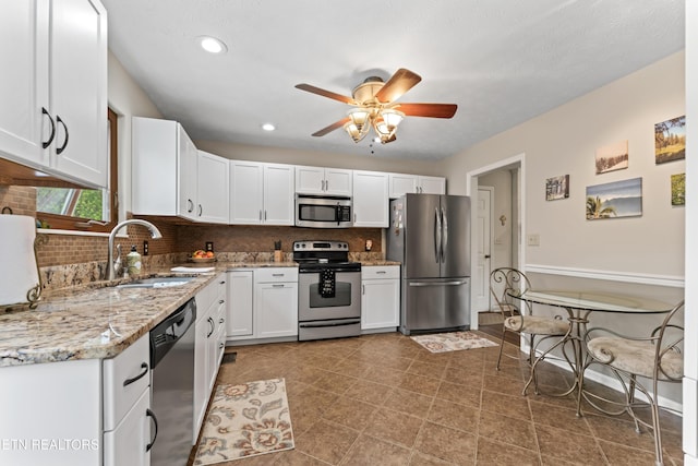 9945 Tierra Verde Dr, Knoxville, TN 37922 - kitchen featuring stainless steel appliances, a sink, white cabinets, decorative backsplash, and ceiling fan