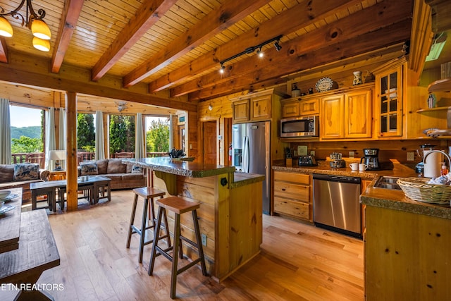 kitchen with appliances with stainless steel finishes, a sink, wood ceiling, a kitchen island, and light wood-style flooring