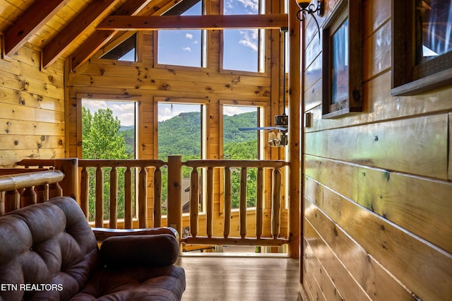 doorway to outside with wood walls, healthy amount of natural light, wood finished floors, and wood ceiling