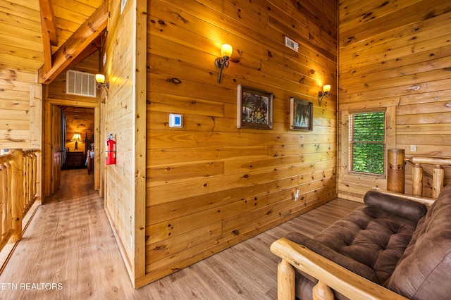 sitting room featuring wooden walls and light wood-style flooring
