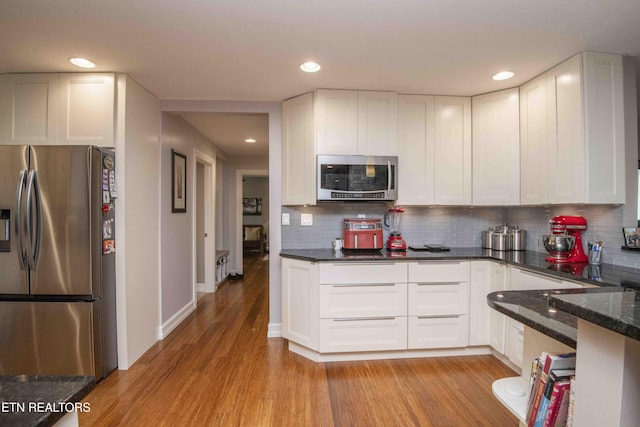 409 Celebration Rd, Knoxville, TN 37934 - kitchen featuring appliances with stainless steel finishes, light wood-type flooring, backsplash, white cabinetry, and recessed lighting