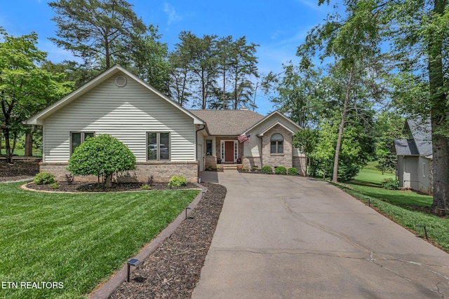 single story home with a front lawn, brick siding, and concrete driveway