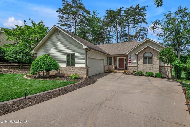 ranch-style home with brick siding, an attached garage, concrete driveway, a front lawn, and a shingled roof