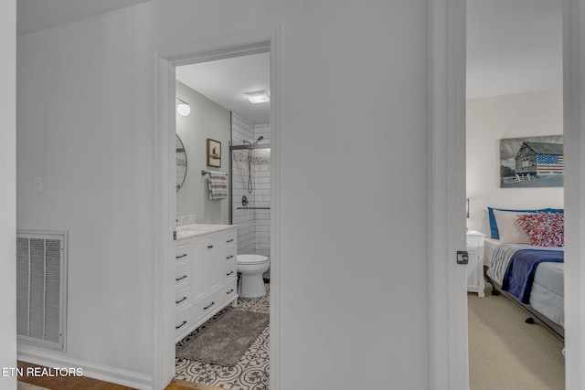 bedroom with ensuite bath and baseboards