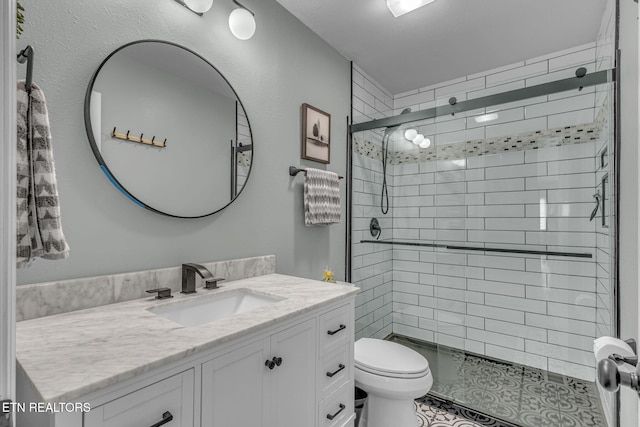full bathroom featuring toilet, vanity, and a stall shower