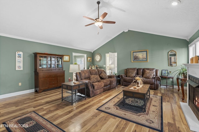 3083 Waters Edge Dr, Morristown, TN 37814 - living room with a lit fireplace, ceiling fan, vaulted ceiling, wood finished floors, and baseboards