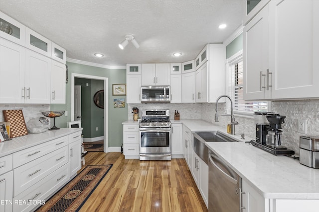 3083 Waters Edge Dr, Morristown, TN 37814 - kitchen featuring appliances with stainless steel finishes, a sink, decorative backsplash, white cabinets, and crown molding