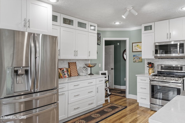 3083 Waters Edge Dr, Morristown, TN 37814 - kitchen with stainless steel appliances, light countertops, white cabinets, a textured ceiling, and ornamental molding