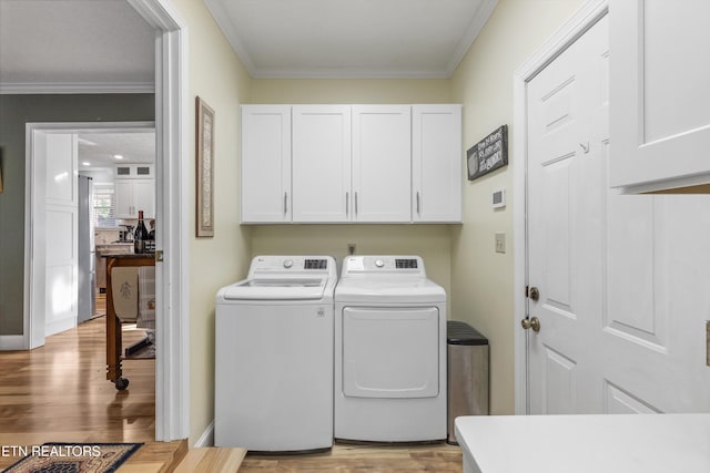 3083 Waters Edge Dr, Morristown, TN 37814 - washroom with separate washer and dryer, cabinet space, light wood-type flooring, and crown molding
