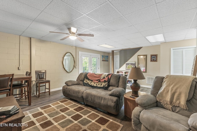 3083 Waters Edge Dr, Morristown, TN 37814 - living room featuring ceiling fan, wood finished floors, a paneled ceiling, baseboards, and concrete block wall