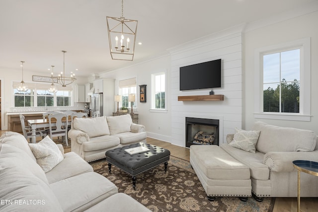 819 NW Morgan Rd, Charleston, TN 37310 - living room with a chandelier, wood finished floors, ornamental molding, a large fireplace, and recessed lighting