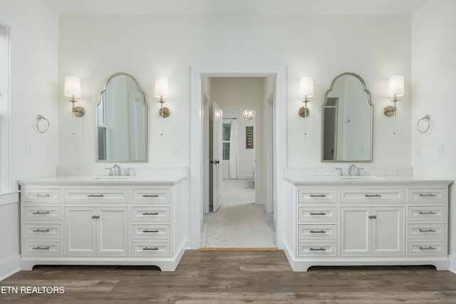 819 NW Morgan Rd, Charleston, TN 37310 - bathroom featuring wood finished floors, two vanities, and baseboards