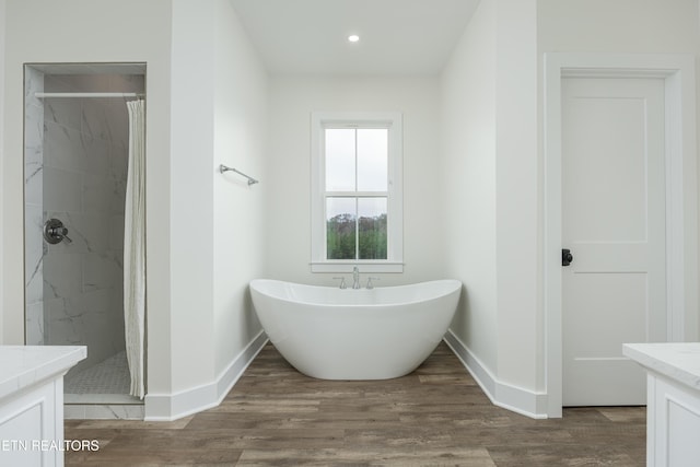 819 NW Morgan Rd, Charleston, TN 37310 - bathroom featuring a shower with shower curtain, vanity, baseboards, wood finished floors, and a freestanding bath