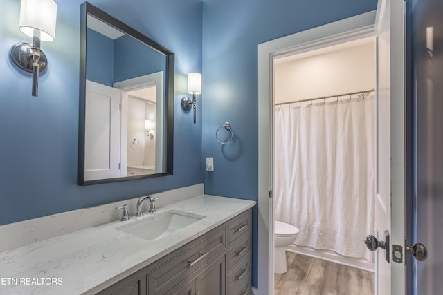 819 NW Morgan Rd, Charleston, TN 37310 - bathroom featuring wood finished floors, toilet, vanity, and shower / tub combo with curtain