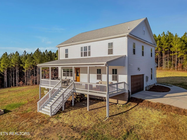 819 NW Morgan Rd, Charleston, TN 37310 - view of front facade with a porch, concrete driveway, a garage, and a front yard