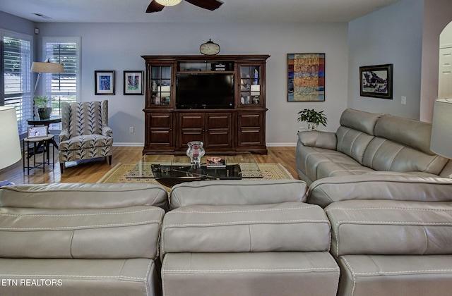 living room featuring wood finished floors, ceiling fan, and baseboards