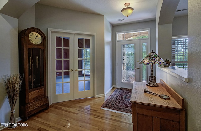 entrance foyer with french doors, wood finished floors, a textured wall, and baseboards
