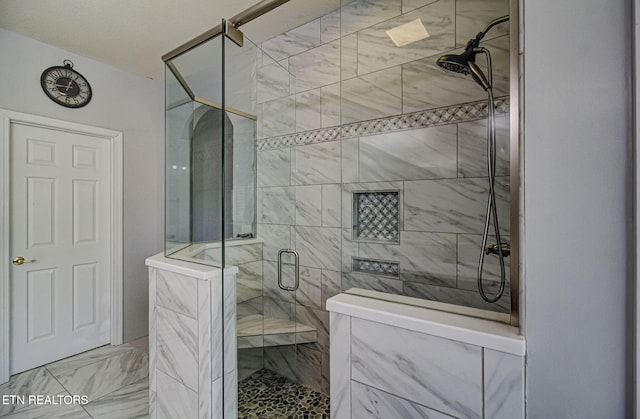 full bathroom featuring a stall shower and marble finish flooring